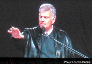 Franklin Graham shown at a podium speaking at a festival in Poland.
