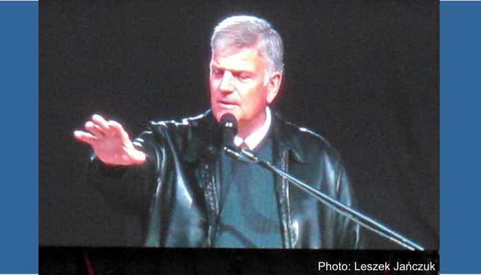 Franklin Graham shown at a podium speaking at a festival in Poland.