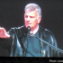 Franklin Graham shown at a podium speaking at a festival in Poland.